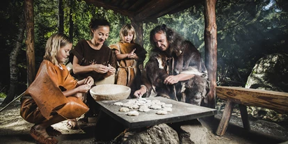 Ausflug mit Kindern - Alter der Kinder: über 10 Jahre - Tirol - Steinzeitfamilie beim Brotbacken im Ötzi-Dorf - Ötzi-Dorf und Greifvogelpark