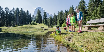 Ausflug mit Kindern - Umgebungsschwerpunkt: See - Raas (Trentino-Südtirol) - Das Wasserbiotop mit Kneippmöglichkeit
Das Wasserbiotop lädt zum aufblühen ein! Kleine und große Wanderer können hier die Zehen und Füße in das kühle Wasser der kleinen Kneippanlage stecken oder barfuß das Gras rund um das Biotop ertasten. Bequeme Holzliegen mitten im Grünen sorgen für erholsame Ruhemomente. - Naturerlebnisweg PanaRaida in Gröden/Val Gardena