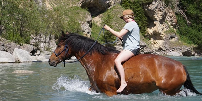 Voyage avec des enfants - Davos Glaris - Baden im Fluss zu Pferd an einem heissen Sommertag - Stalla Chapella / Bogenparcours Engadin