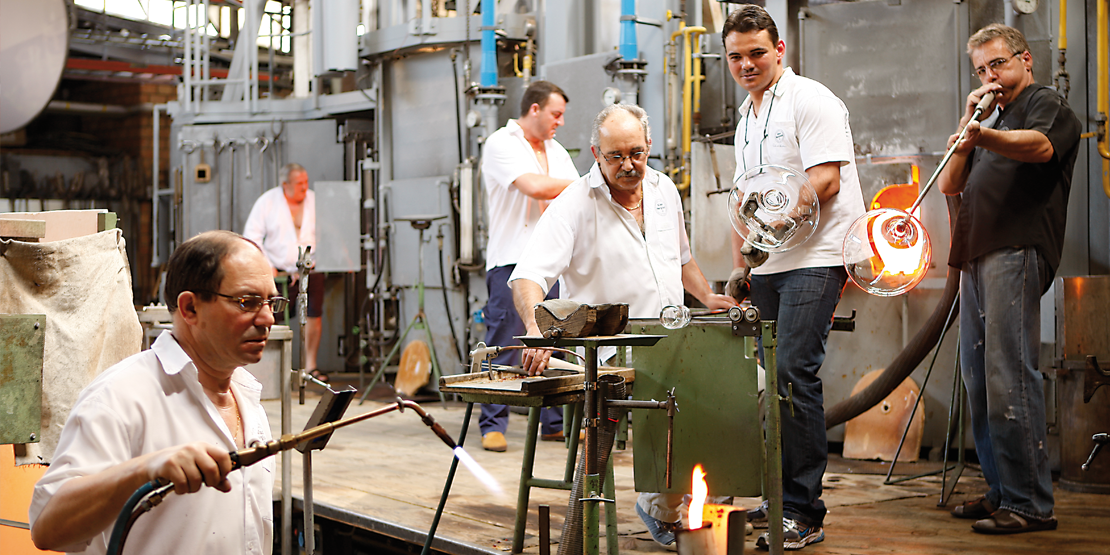 Destination - Bei bester Sicht auf die Glasmacher-Plattform können Sie den Handwerkern bei ihrer rhythmischen Arbeit zuschauen und selber entdecken, wie mit handwerklichem Geschick aus der glühenden Masse Gläser geformt, geblasen und gegossen werden.

Unsere Glasmacher kommen aus Portugal und Italien. Sie arbeiten von Montag bis Freitag von 9.30 bis 13.00 Uhr und von 13.30 bis 17.00 Uhr, am Samstag von 9.30 bis 12.30 Uhr und von 13.00 bis 16.00 Uhr.
Früher bildeten wir auch Lehrlinge aus. Eine Ausbildung ist heute nur noch im Ausland möglich, zum Beispiel an der Glasfachschule in Zwiesel, Deutschland. - Glasi Hergiswil