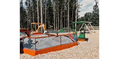Ausflug mit Kindern - Ausflugsziel ist: ein Freizeitpark - Österreich - Hydraulische Bagger im Waldpspielpark Zahmer Kaiser an der Bergstation des 4er Sessellift - Waldspielpark im Freizeitpark Zahmer Kaiser
