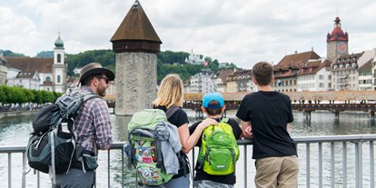 Ausflug mit Kindern - Ausflugsziel ist: ein sehenswerter Ort - Schweiz - Ein Familien-Ausflug in die Stadt Luzern. Im Hintergrund der berühmte Wasserturm mit der Kapellbrücke.
 - Luzern