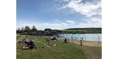 Ausflug mit Kindern - Ausflugsziel ist: ein Bad - Herdwangen-Schönach - Das Strandbad im Seepark Linzgau im Sommer mit Badegästen. Rechts im Bild ist der Kinderspielbereich zu sehen.  - Strandbad im Seepark Linzgau