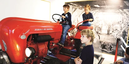 Ausflug mit Kindern - Schatten: vollständig schattig - Wertheim (Neumarkt am Wallersee) - Kinder am Traktor Simulator im fahr(T)raum - fahr(T)raum - Ferdinand Porsche Erlebniswelten
