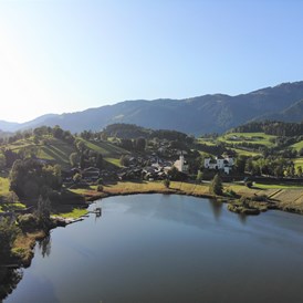 Ausflugsziel: Luftaufnahme mit Blick auf den Goldegger See, die Badeanstalt und das Schloss Goldegg. - Moorbadeanstalt