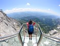 Ausflugsziel: Die Treppe ins Nichts führt dich über 14 schmale Stufen hinab auf ein Glaspodest in schwindelerregender Höhe. - Dachstein Seilbahn & Gletscher
