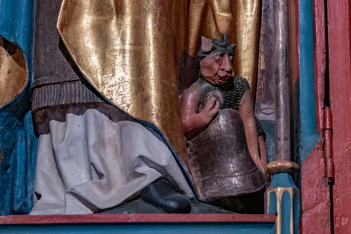 Ausflugsziel: Teufel mit der Glocke am Fuße von Bischof Theodul in der St. Agatha Kapelle am Kristberg im Silbertal, dem Genießerberg im Montafon - Der Sagenwanderweg (Sagenweg) vom Kristberg ins Silbertal