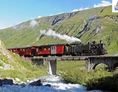 Ausflugsziel: Dampfzug mitten in der Natur zwischen Felsen, Wasser und Brücken. - Dampfbahn Furka Bergstrecke