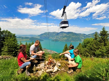 Ausflugsziel: Familie beim Picknick auf der Klewenalp. Im Hintergrund die Luftseilbahn Beckenried-Klewenalp - Goldi-Familiensafari