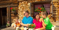 Ausflug mit Kindern - Witterung: Schönwetter - Die ganze Familie lässt sich die Brettljause schmecken - Palfner Alm Rauris