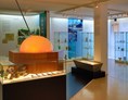 Ausflugsziel: Blick ins Glasmuseum Waldkraiburg, Glasmacherwerkzeug. Hintergrund historische Glasobjekte - Glasmuseum Waldkraiburg
