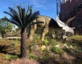 Ausflugsziel: Urzeitmuseum Taufkirchen - Außenaufnahme. Triceratops hinter Palme - Urzeitmuseum – Sammlung Kapustin
